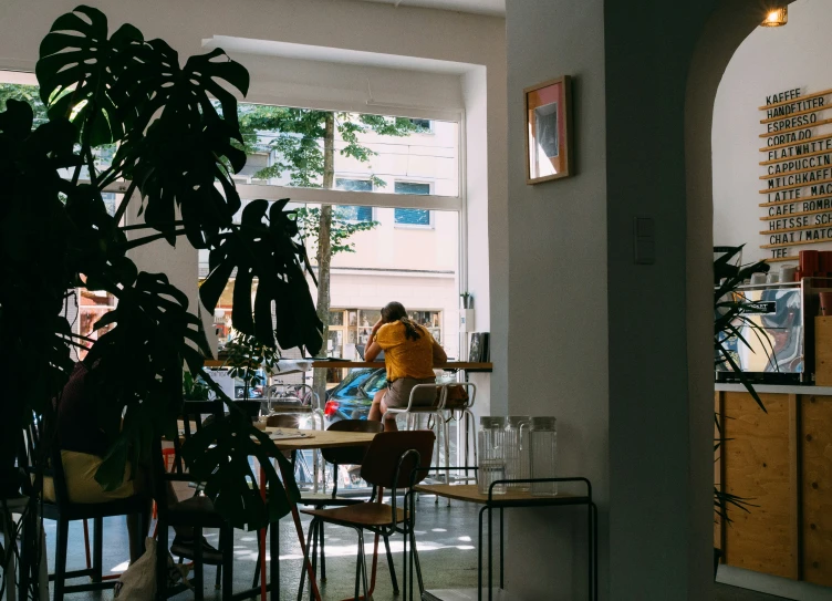 some people sitting at a table near a plant and other items