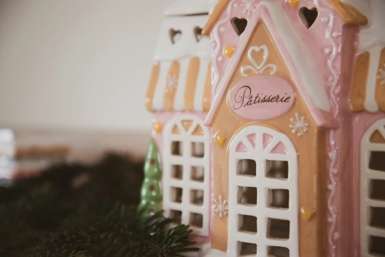 a pink gingerbread house is decorated with hearts