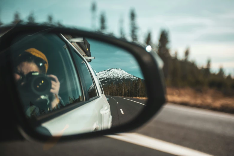 a rear view mirror shows a person taking a po