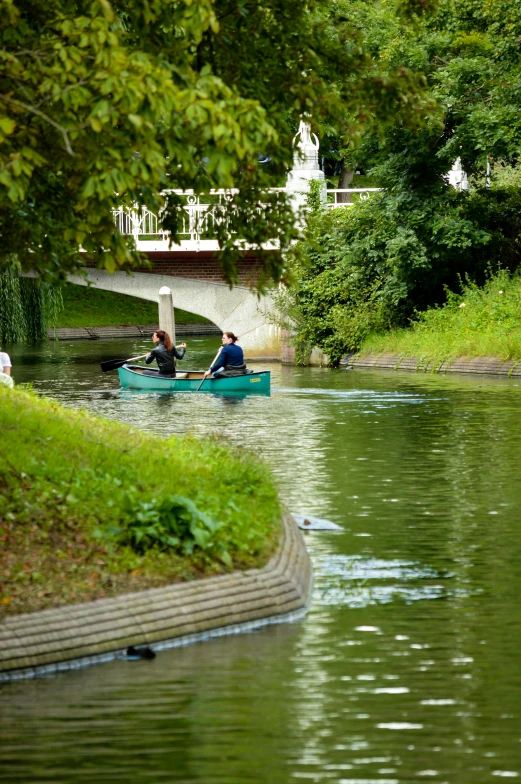 the two people are in a small boat by the water