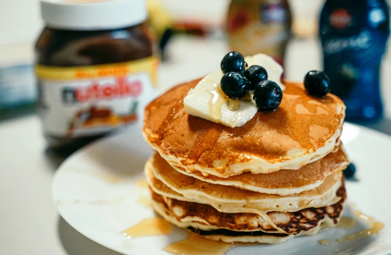 a stack of pancakes with blueberries and syrup