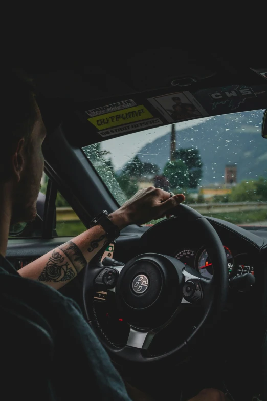 the man is sitting behind the wheel of his car