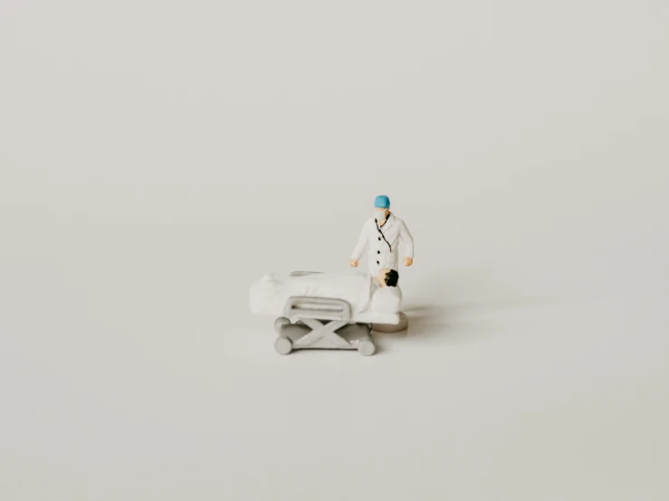 miniature white and blue figures sitting on top of a white surface