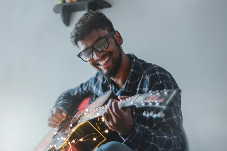 a man playing the guitar and smiling
