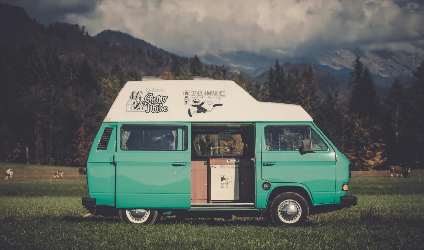 an old style van with the door opened and a small fridge in front