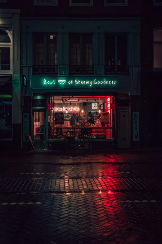 a green store sign sitting inside of a dark street