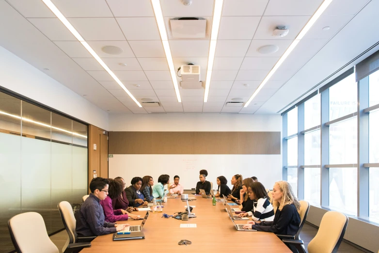 a meeting room is full of people all in different poses sitting at tables