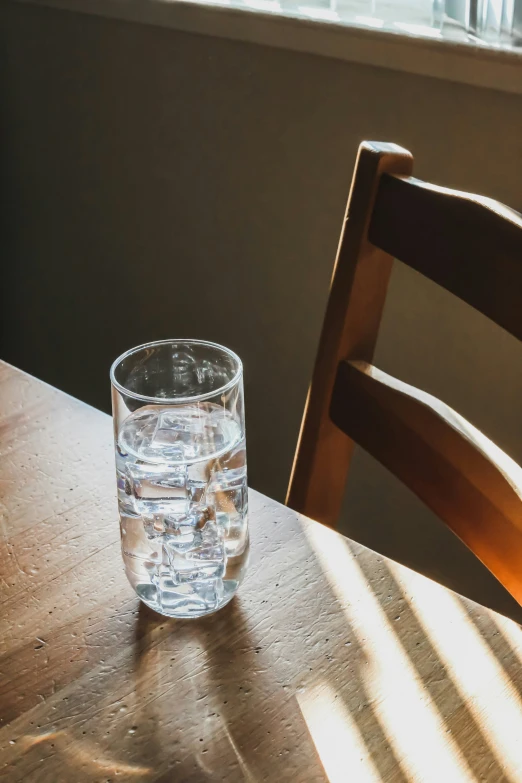 an empty glass is sitting on a wooden table