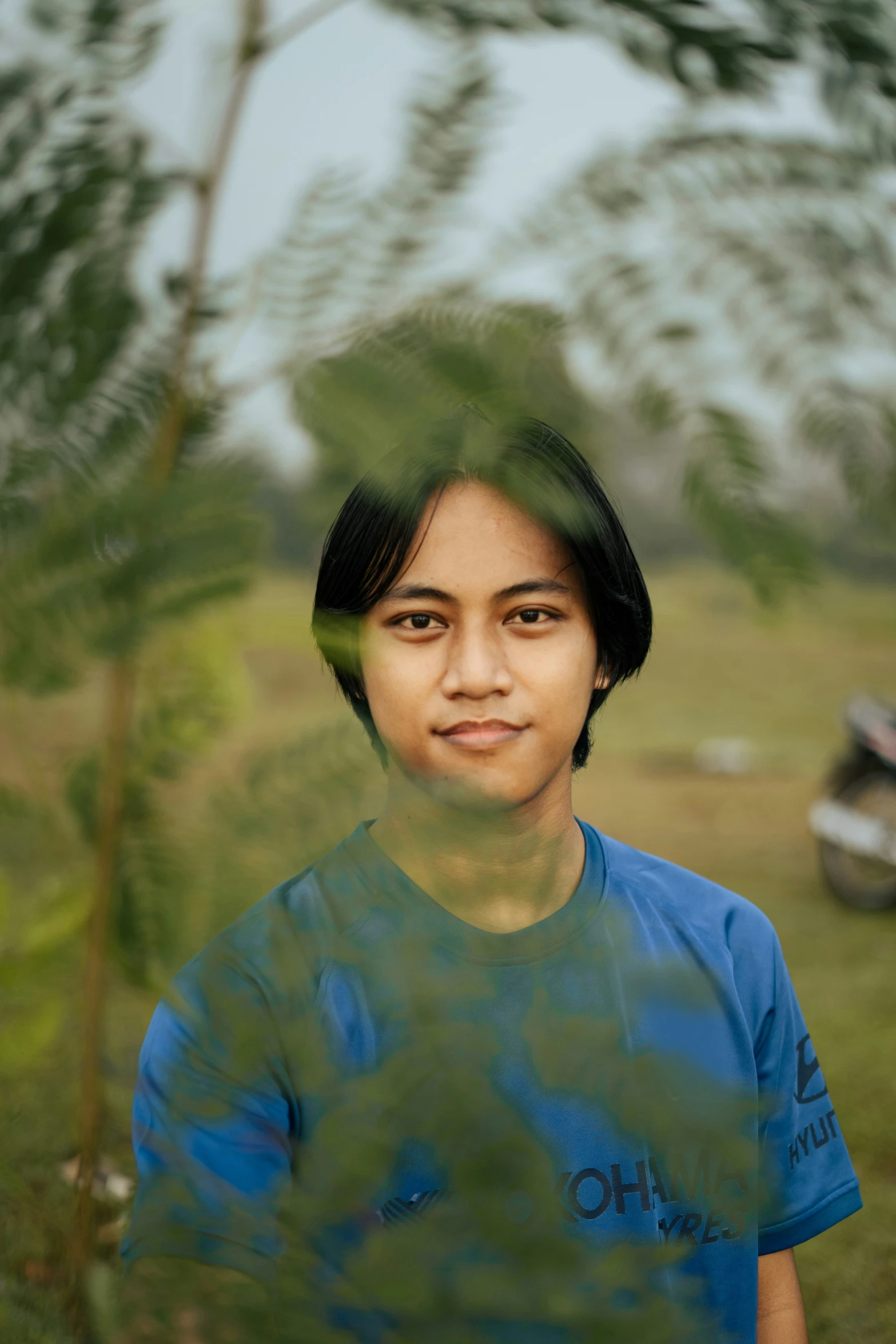 a women standing in front of trees looking at the camera