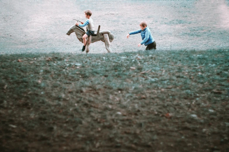 the two people are riding horses through the field