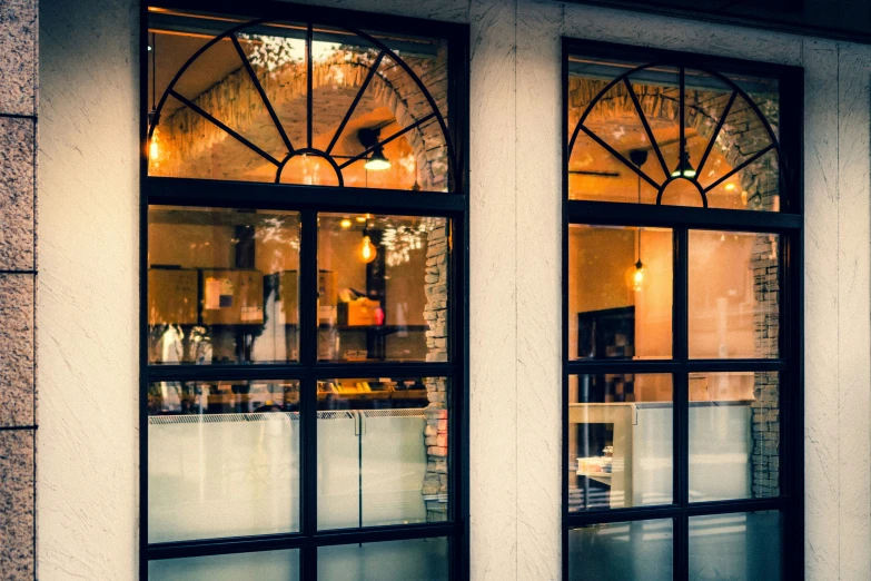 a pair of windows with a white building behind them