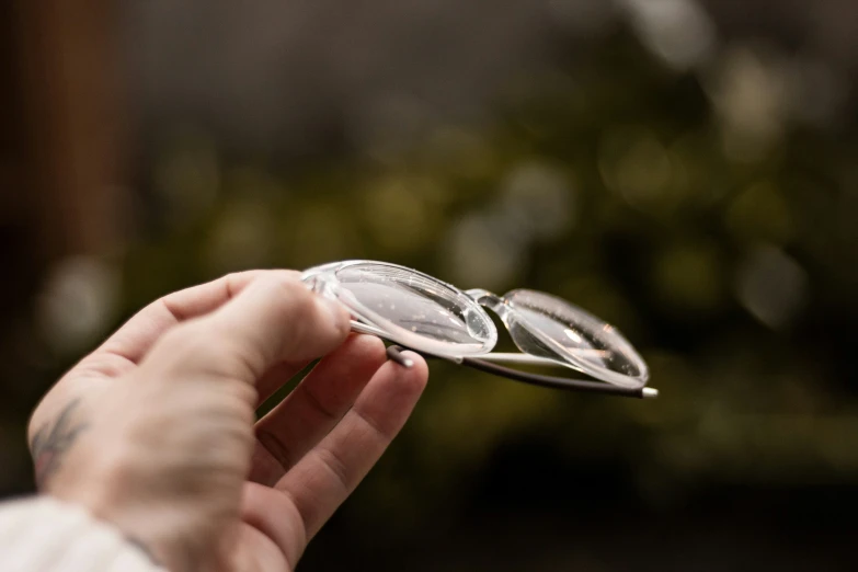 an individual's hand holding a magnifying glass with both hands