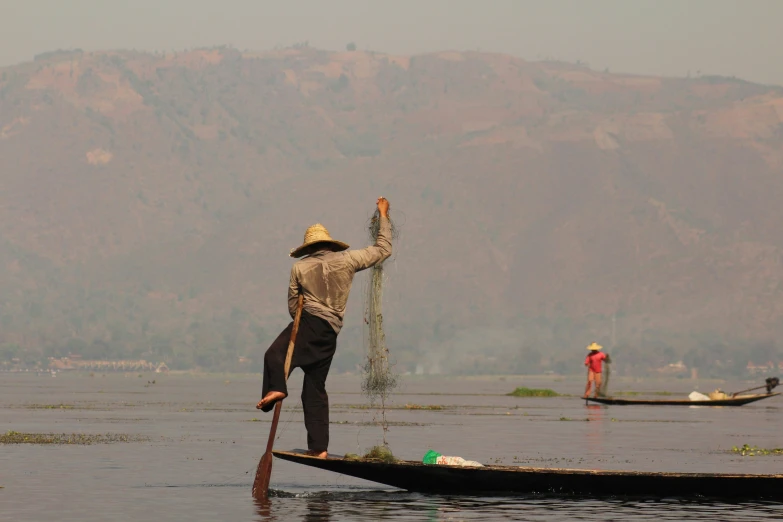 a man standing on a boat on a lake