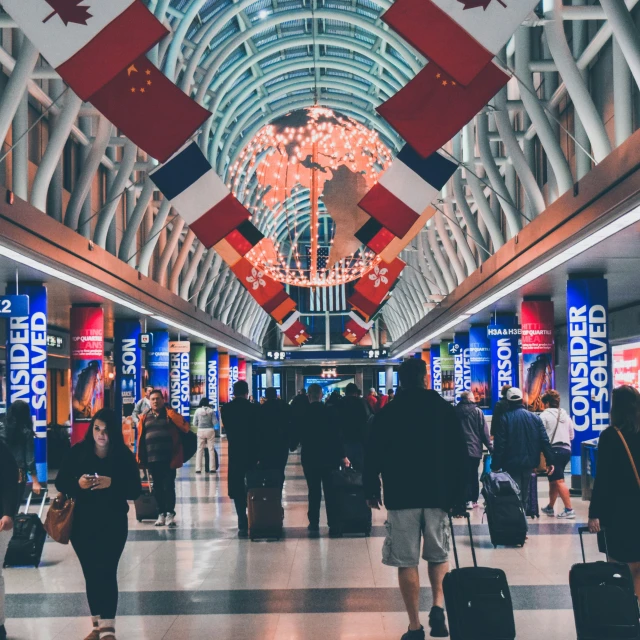 people walking in the airport while carrying luggage