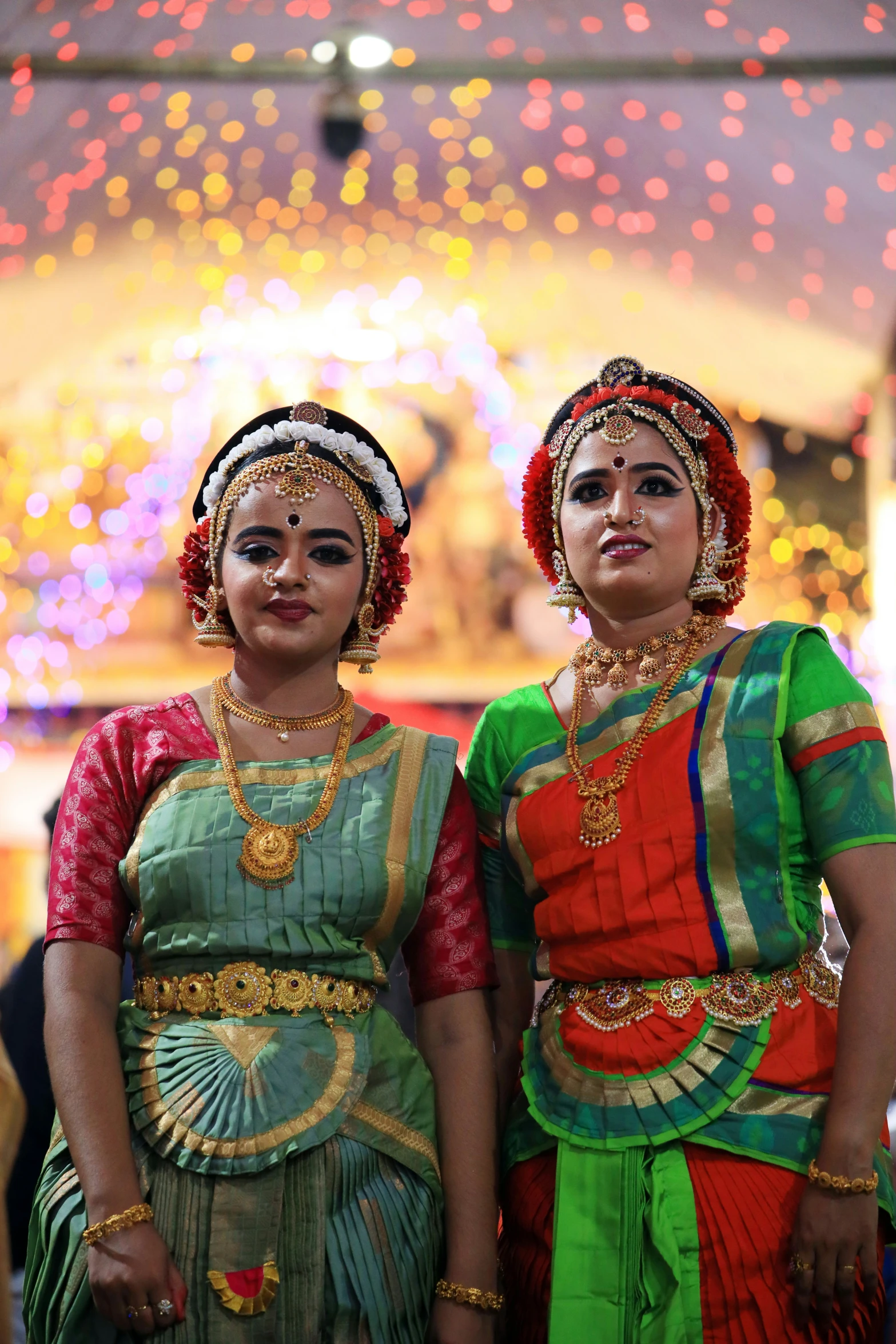 two indian women wearing beautiful costumes posing for the camera