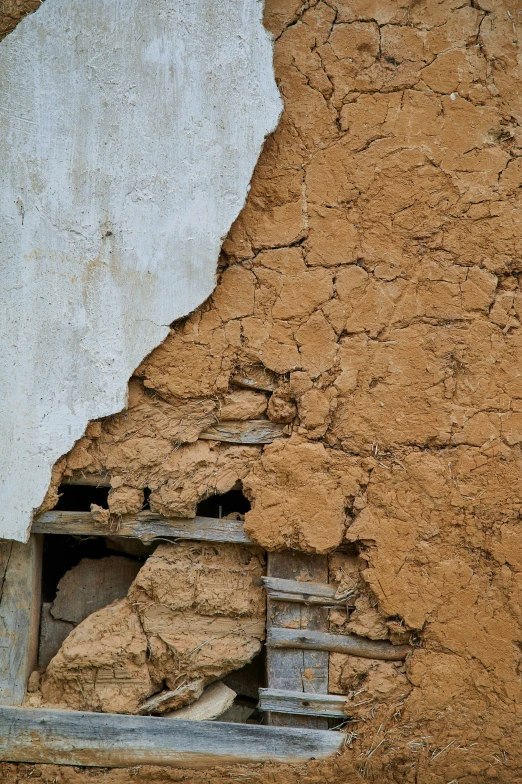 an old brick building with dirt growing around it