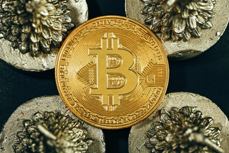 a pile of gold bitcoins with other coins