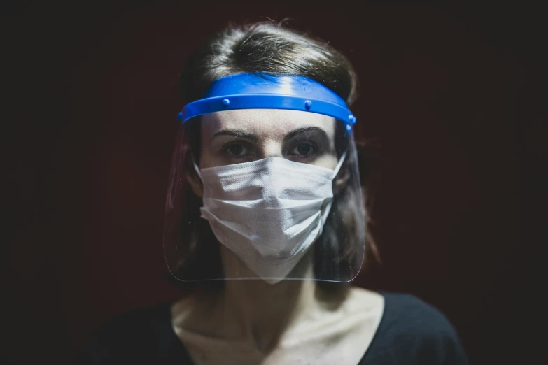 a person wearing a plastic mask and a blind on her head