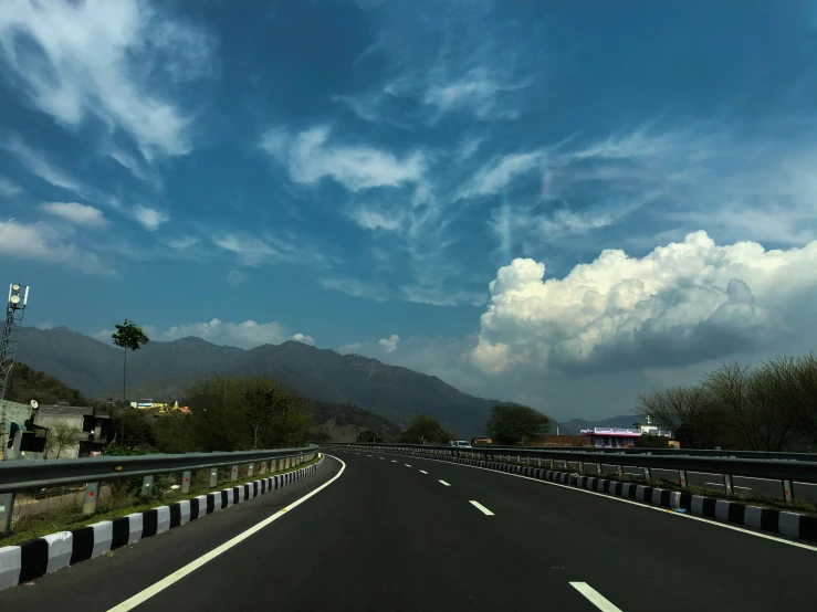 a car traveling on a wide open road under blue sky