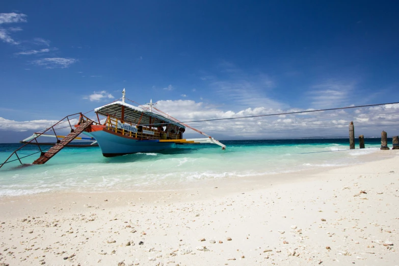 a boat sitting at the edge of the water in the ocean