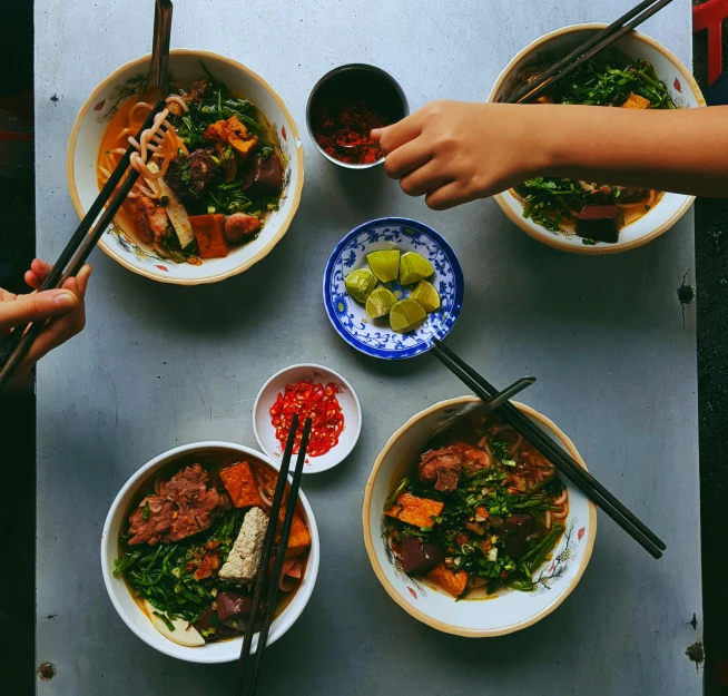 bowls of food on a table with chopsticks and soup