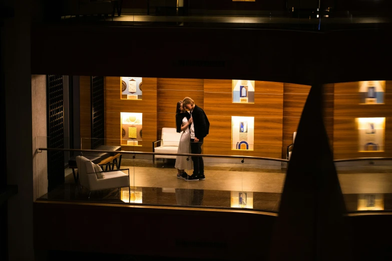 a man standing in an indoor atrium looking down at his phone