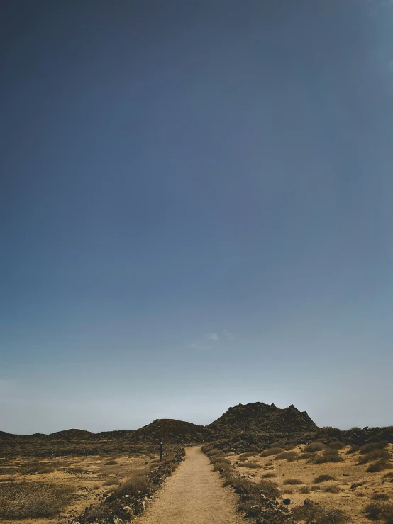 a truck is parked on a gravel road in a dry terrain