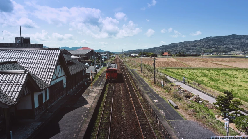 a train travels down the track next to a small village