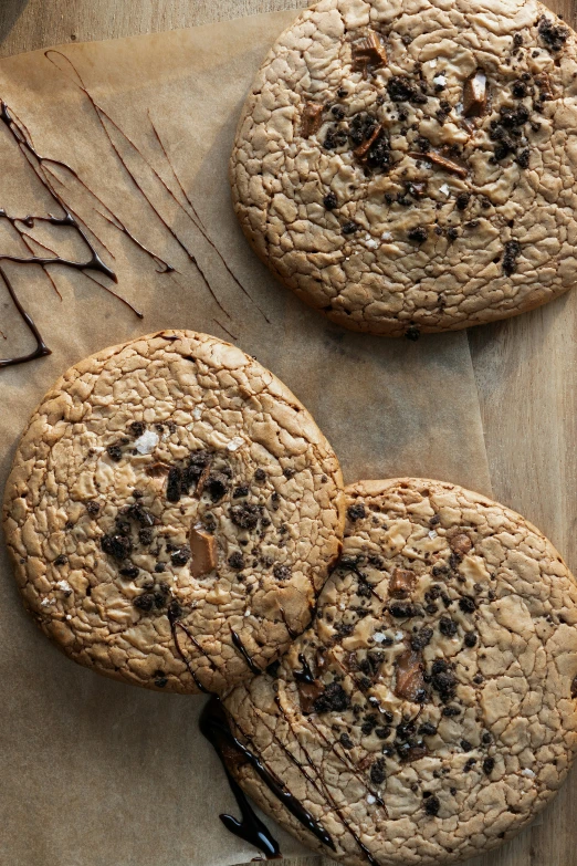 three cookies are sitting on some wax paper