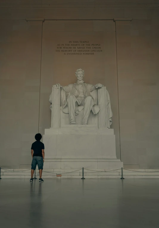 a small child standing in front of a statue