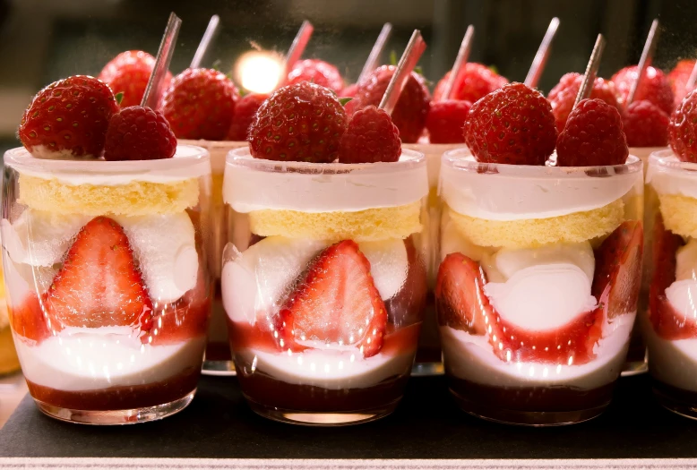 desserts in mason jars with strawberries and strawberry toppings