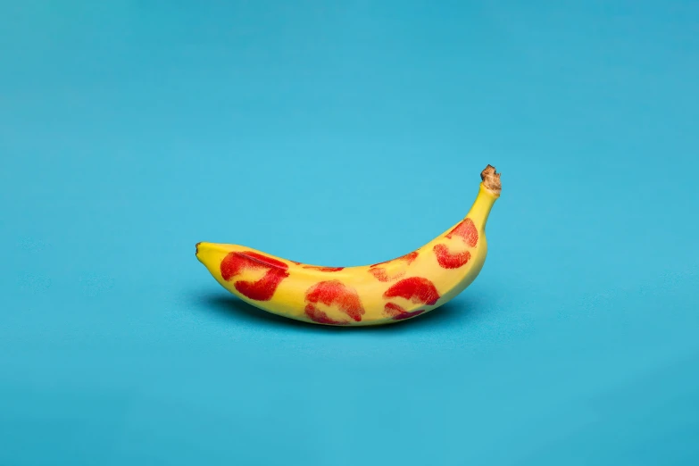 a banana with fruit designs on it on a blue surface