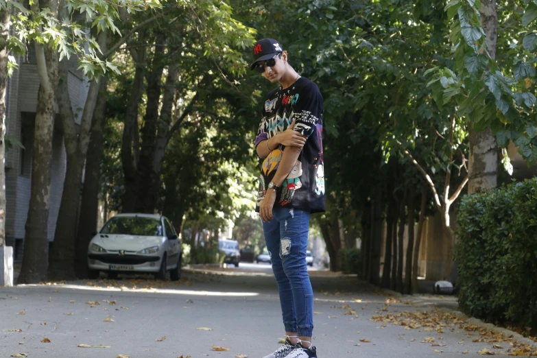 a skateboarder standing with his hand on the skateboard