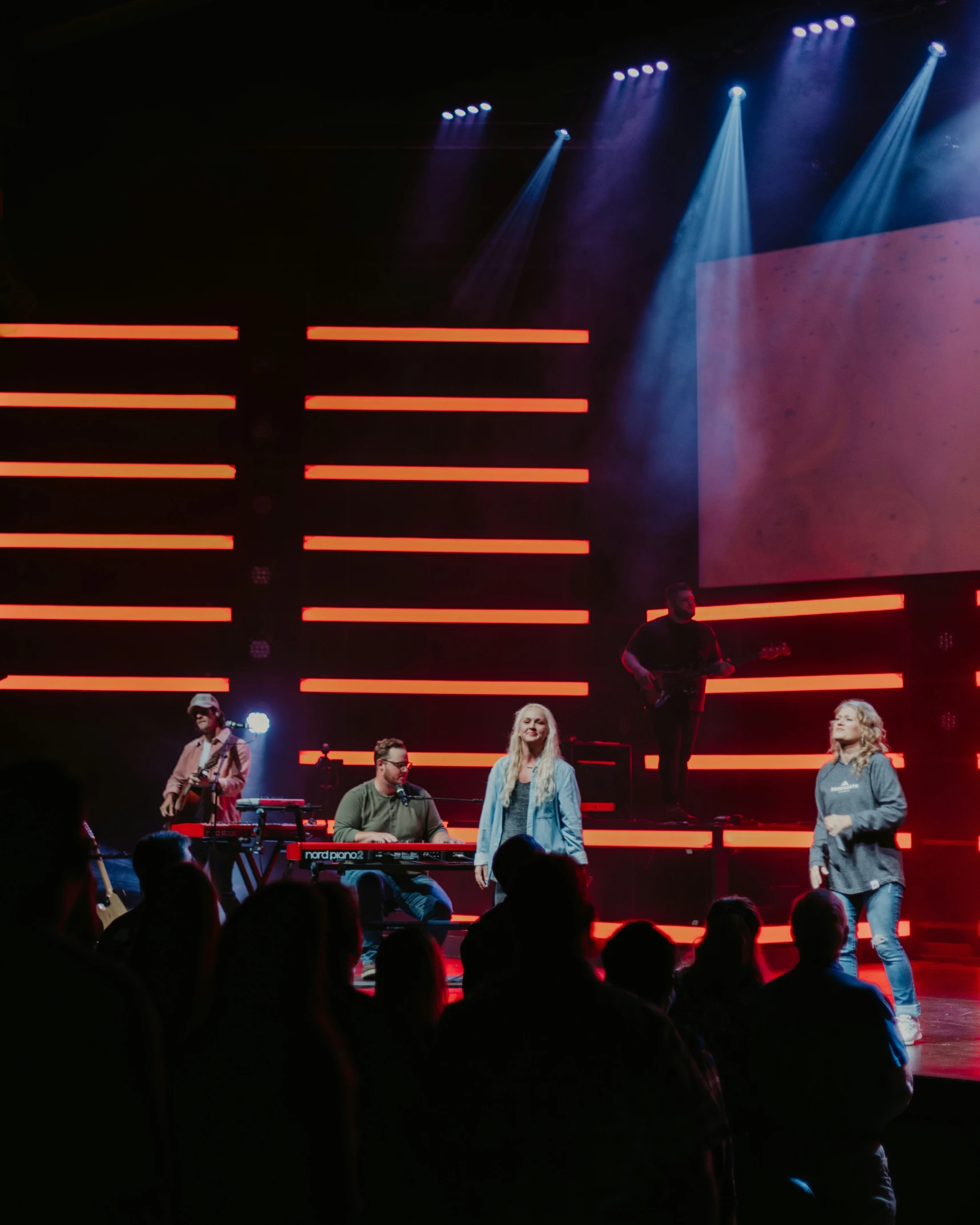 the singer is surrounded by the other people as they stand on stage