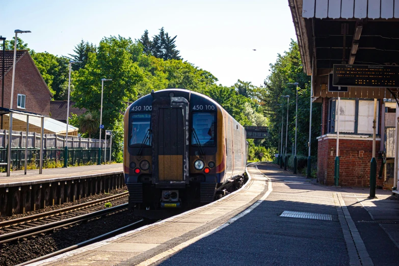 a small train stopped on the tracks near a station