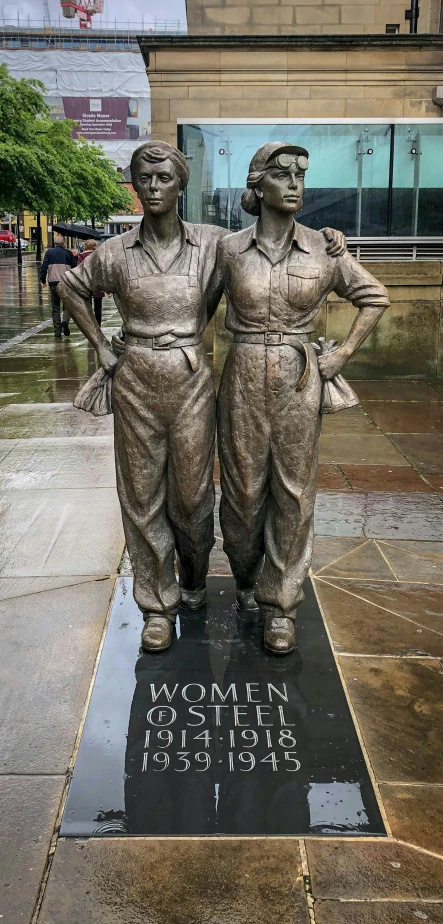 a statue of two men on a rainy street