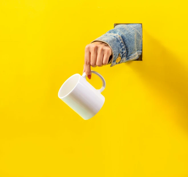 the man is pointing at a cup on the wall