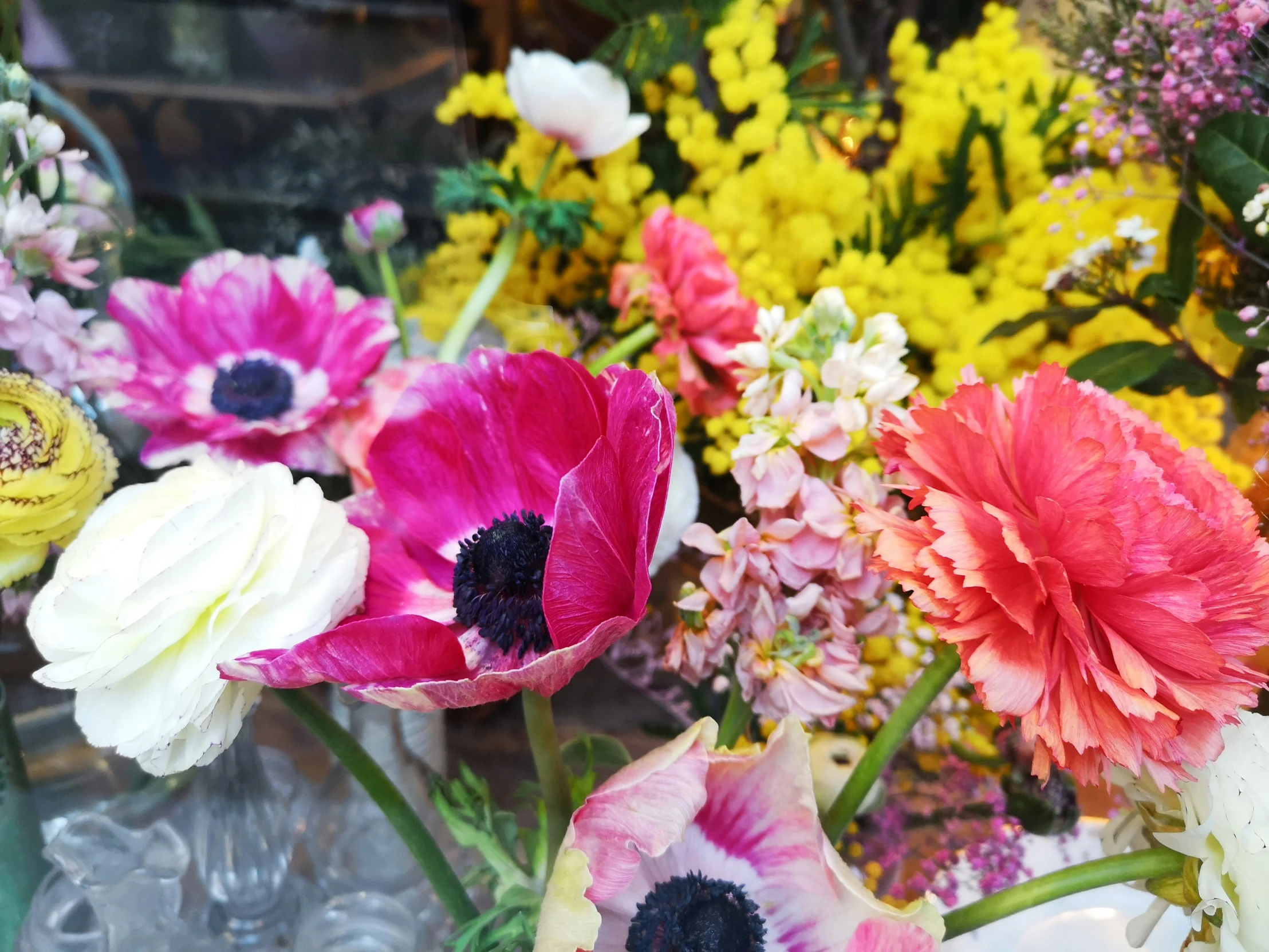 large assortment of colorful flowers sitting in a vase