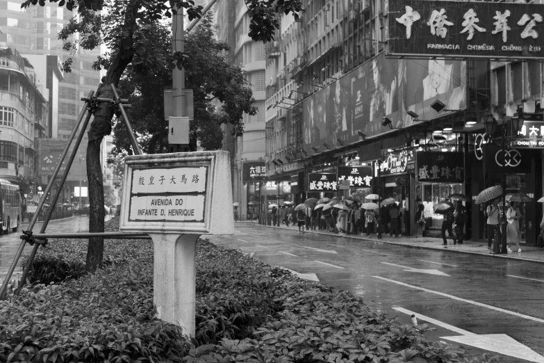 people are standing outside a street in the rain