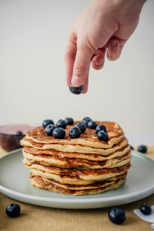 a stack of pancakes with blueberries on the plate