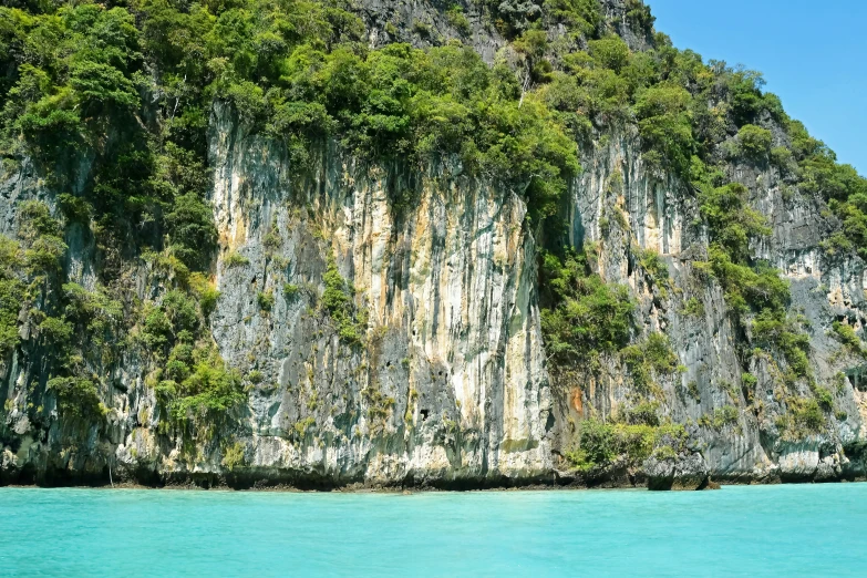 two boats on water near very tall mountain