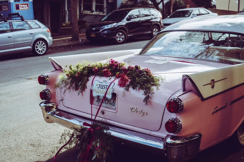 pink car parked in a city near the curb