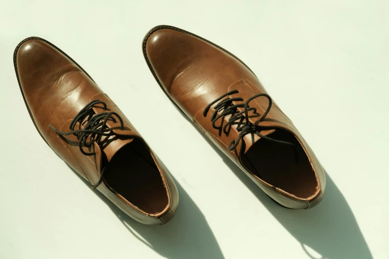 shoes with laces are laid on a plain surface