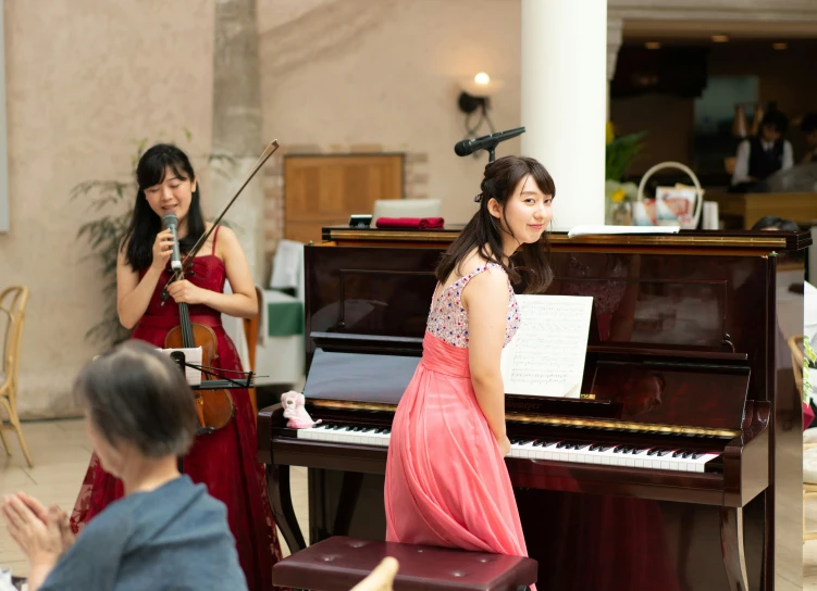 the woman is playing on the piano and she is wearing a gown