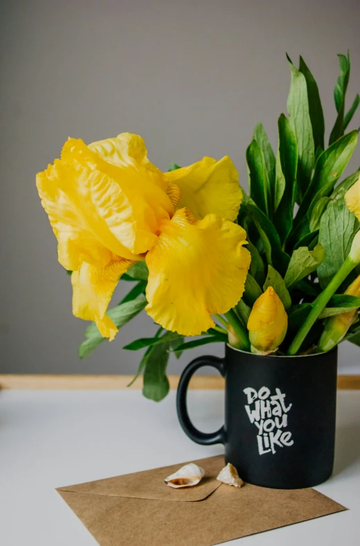 flowers in a cup with a piece of craft paper on the side