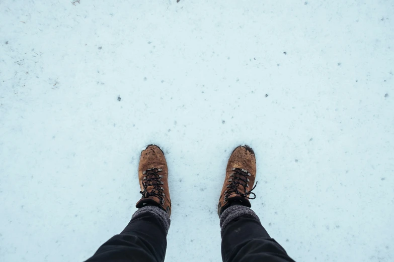a person with boots and a leg crossed out in the snow