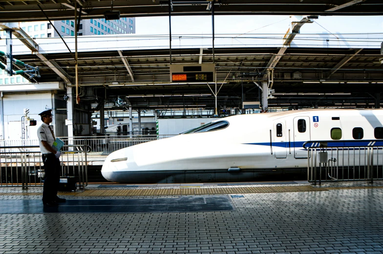 a man waits in front of a modern train