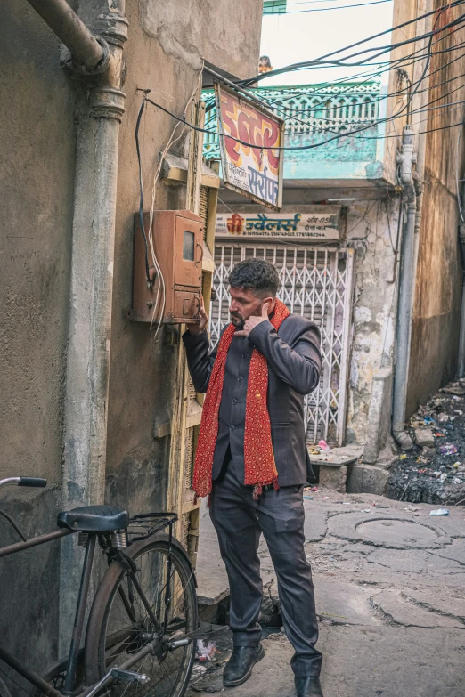 a man is standing by his bike talking on the phone