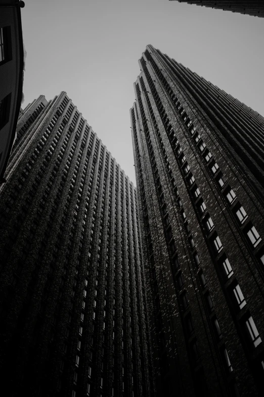 two very tall buildings stand together looking up