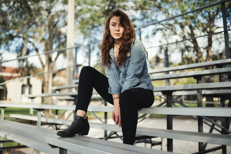 a woman sitting on a metal bench looking into the camera